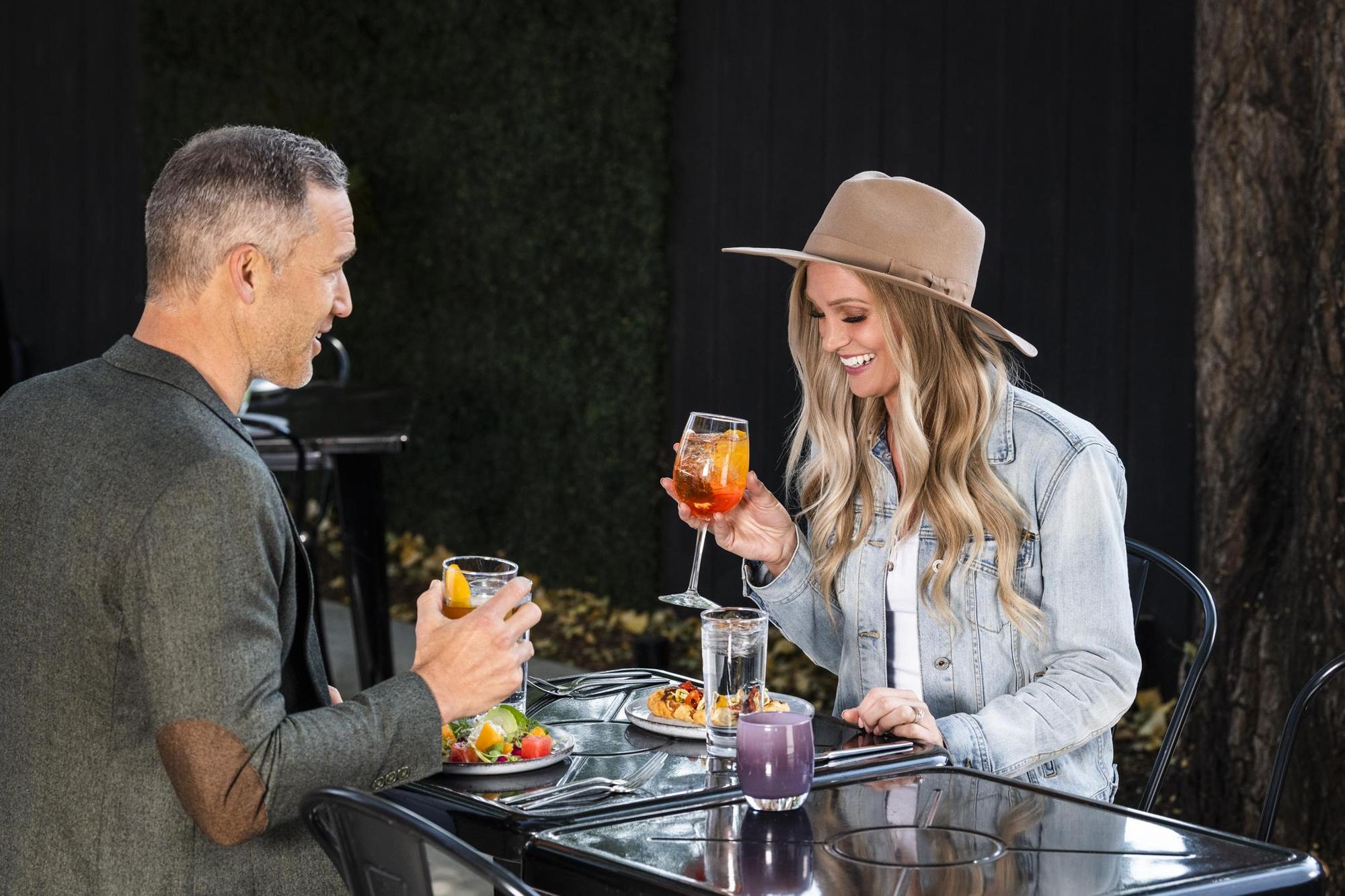 Two diners sipping wine on a patio