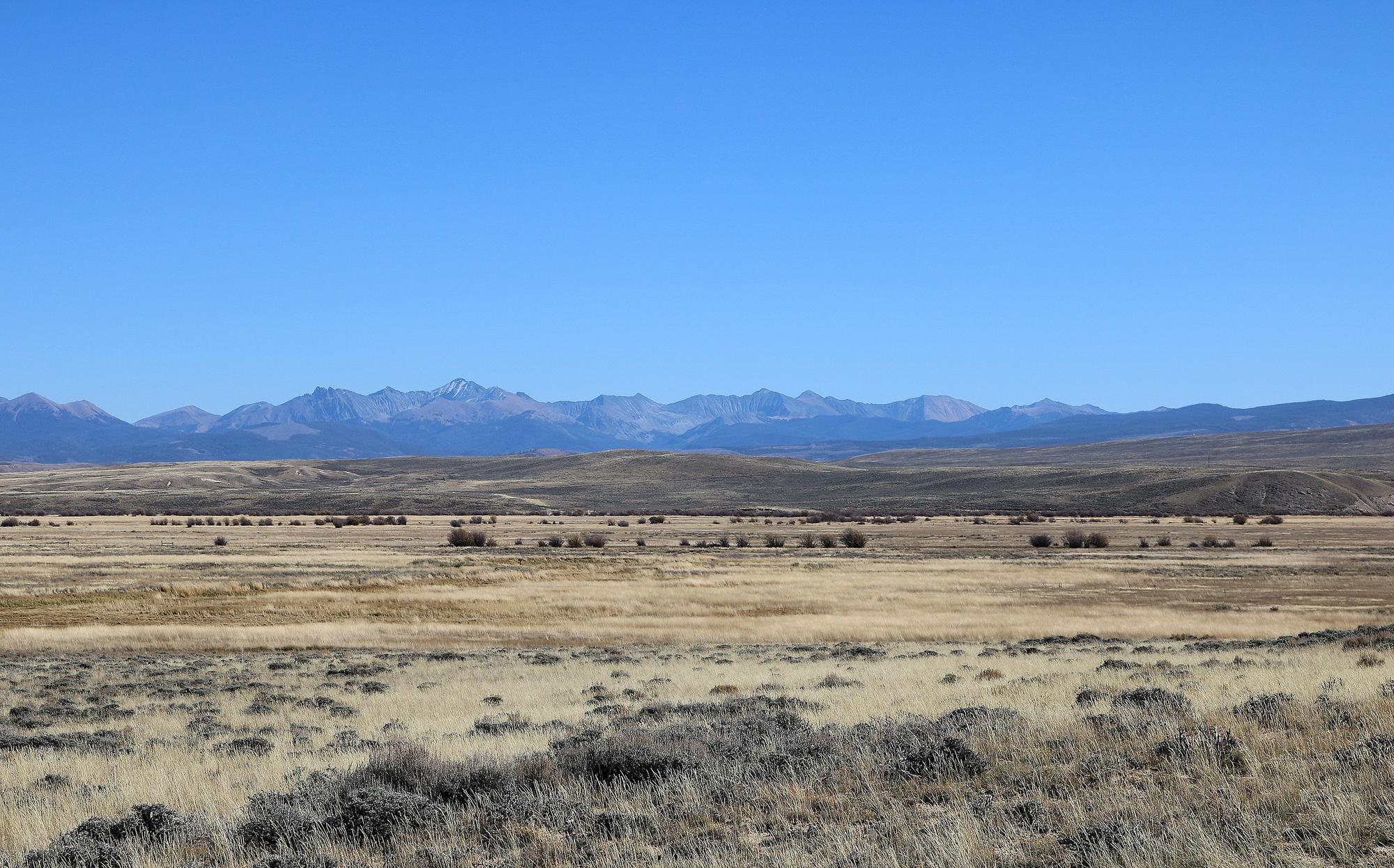 A southwestern prarie that extends far into the distance where it means ridge of mountains - North Park, Jackson County Colorado