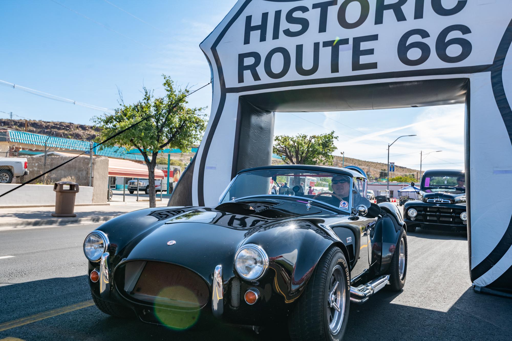 A classic car under an inflatable drive thru shield that reads 