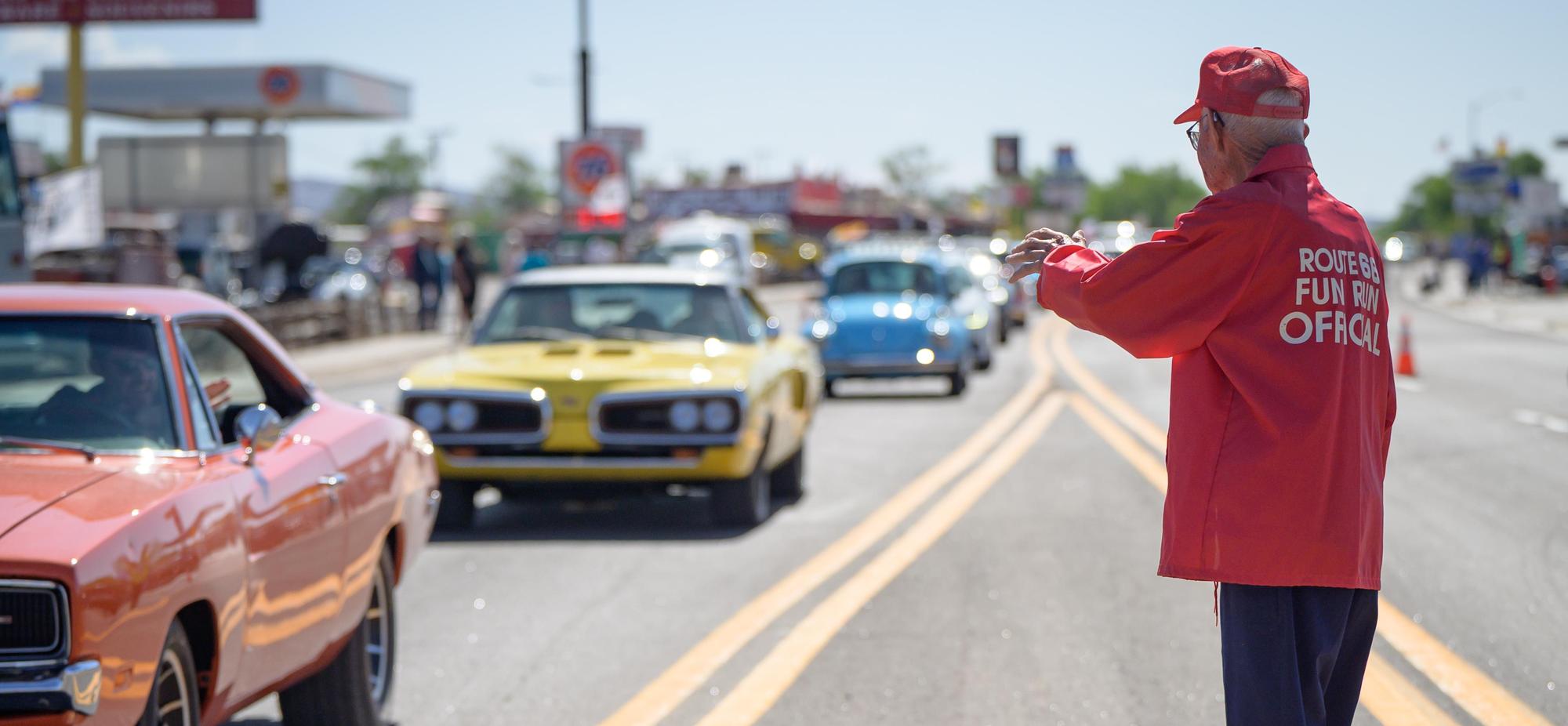 Angel Delgadillo waves to a line of classic cars driving down Route 66 in Seligman, Arizona. 